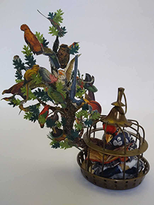 Anthropomorphic Sculpture of a Bird headed woman reading a book, sitting in her cage on a tree branch